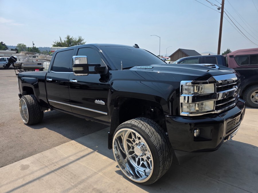 Lifted black Silverado on polished wheels after a full detail